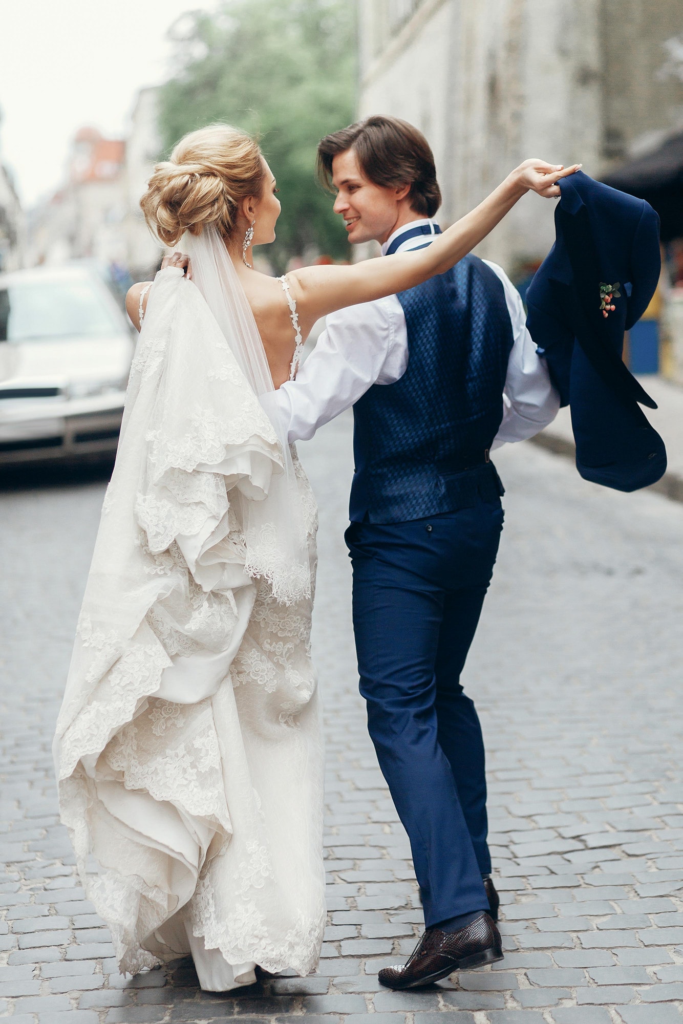 Bride and groom sharing an umbrella on rainy wedding day in Prague